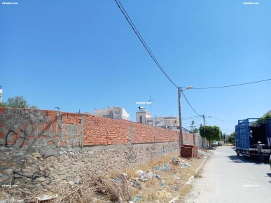 terrain clôturé, titré faisant 410m et ouvrant sur 3 façades.
