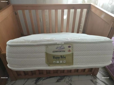 lit bébé avec matelas et accessoires comme photo