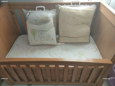 lit bébé avec matelas et accessoires comme photo