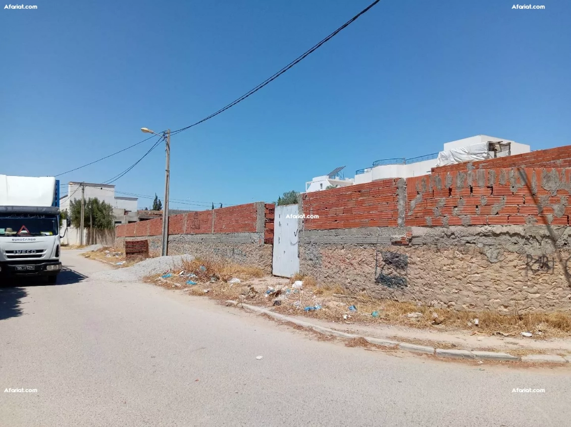 terrain clôturé, titré faisant 410m et ouvrant sur 3 façades.